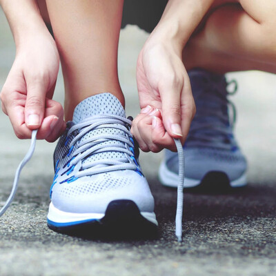 runner lacing runners with new sports orthotics fitted by her chiropodist in Markham and Stouffville